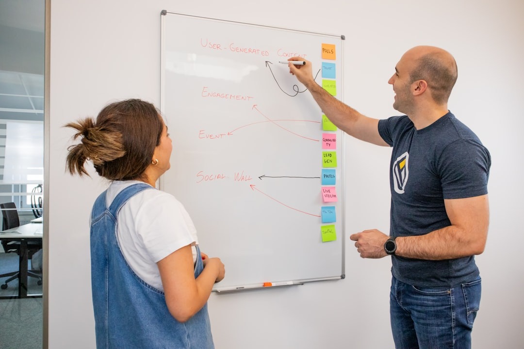 Cross-functional team reviewing a product launch plan on a whiteboard in a bright office
