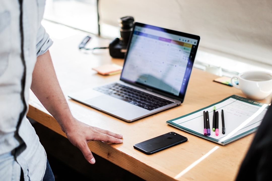 Person checking a launch readiness checklist next to a laptop on a desk
